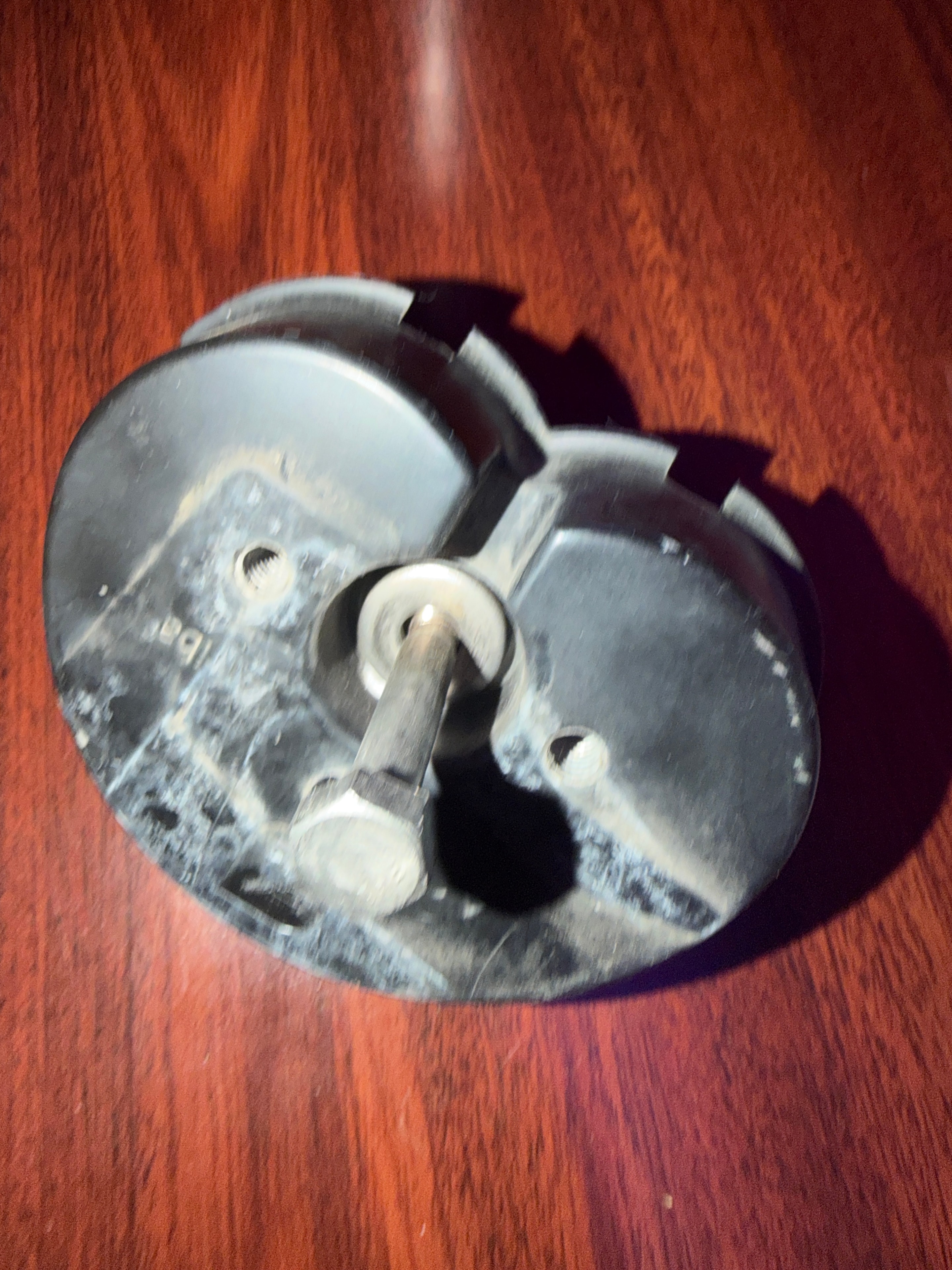 Top view of a Zep solar mounting puck removed from a roof, sealant hardened and cracked after twelve years