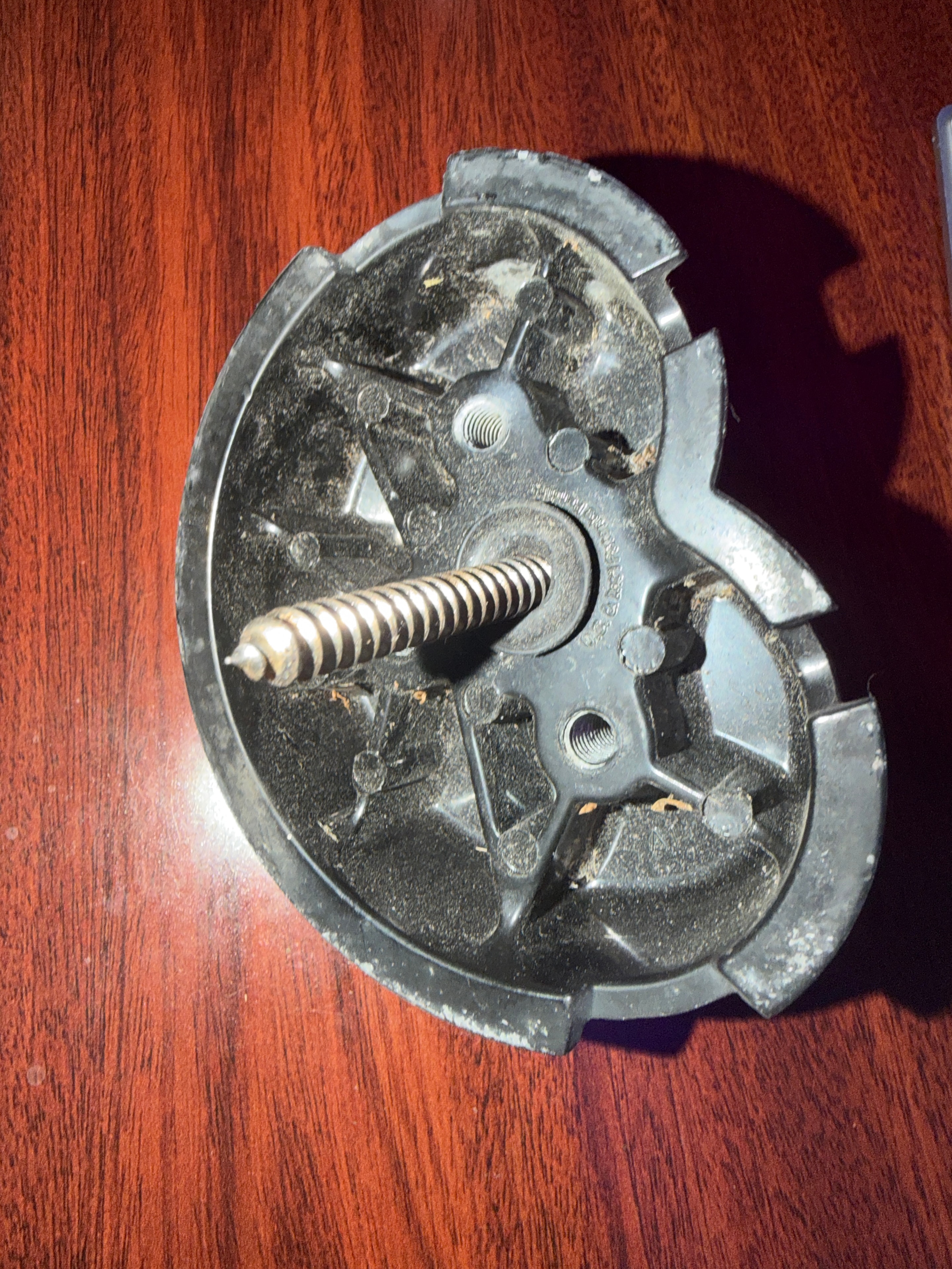 Underside of a Zep solar mounting puck showing the lag screw and worn sealant after twelve years on a roof