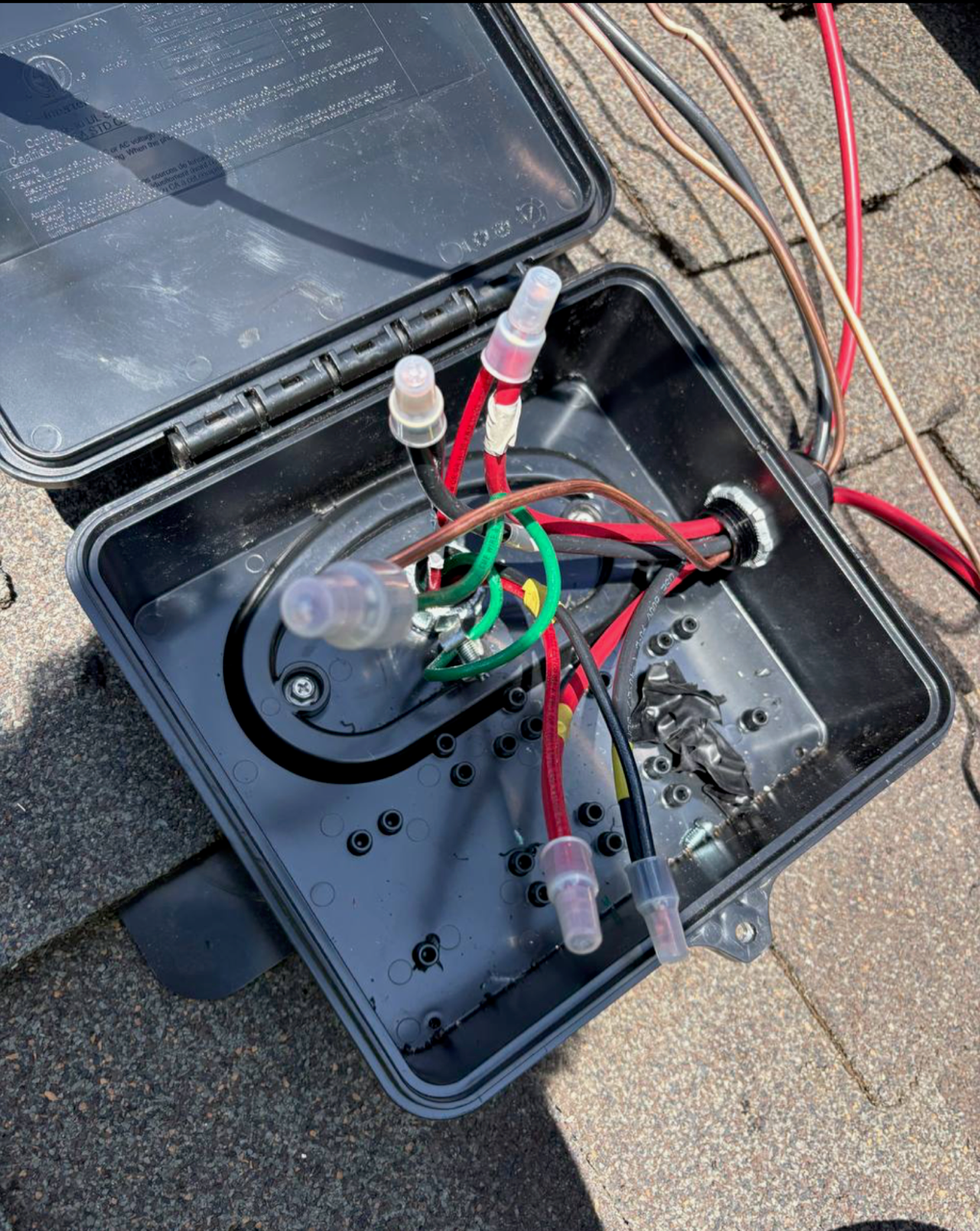 Junction box fully wired with color-coded conductors and sealed connectors.